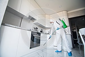 Disinfector in a protective suit conducts disinfection in contaminated area. Professional disinfection against COVID-19,