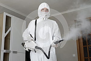 Disinfector in a protective suit conducts disinfection in home. professional disinfection against COVID-19, coronavirus