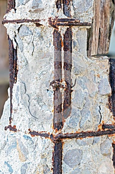 Disintegrated old concrete pillar with damaged and rusty steel f