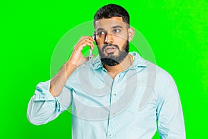 Disinterested tired Indian man having annoyed boring talk on smartphone online conversation, quarrel