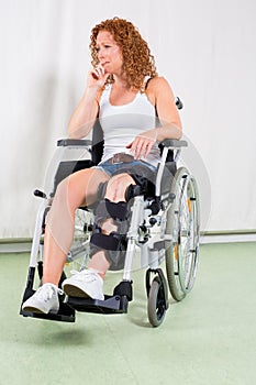 Disinterested woman in wheelchair with hand to lip