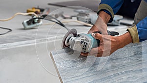 Disk grinder cutting tile in work