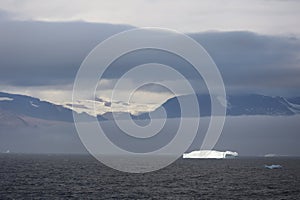 Iceberg under dramatic sky in Disko Bay, Arctic, Greenland, Denmark photo