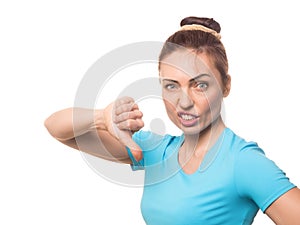 Dislike. Caucasian arrtactive adult woman gives thumbs down gesture with a discontented face, close up, isolated on