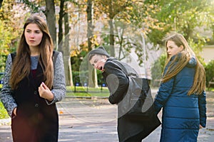 Disloyal man walking with girlfriend and looking amazed at another seductive girl