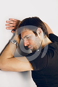 Dismal and sad guy in a black T-shirt and watch on a hand