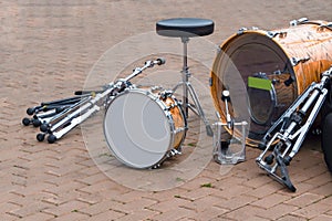 Dismantled drum kit and chair in  square after concert.