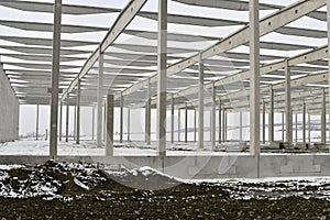 A dismantled factory hall in winter. Construction site during winter. The concept of the end of the building season and the
