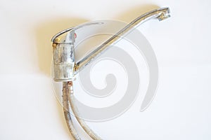 A dismantled  old  lime-coated water tap lies on a white background