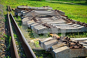 Dismantled old rails and sleepers lie on the green grass