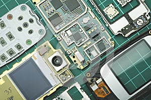Dismantled for spare parts old mobile phone on green background close-up