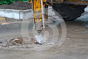 Dismantling of asphalt concrete pavement with pneumatic jackhammer during road works.