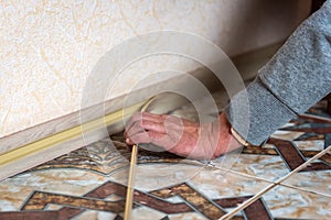 Dismantling the baseboard. Plastic baseboard with hidden mounting system.