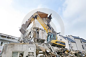 Dismantling old residential building with excavator