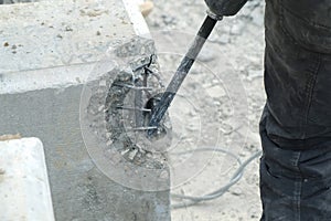 Dismantling of piles of a demolished house using a jackhammer, closeup view.