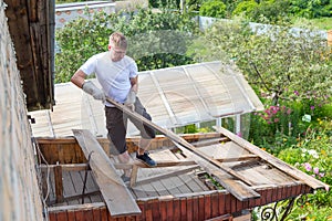 dismantling the roof. The worker removes old boards