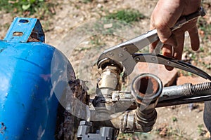 Dismantling the water distribution unit of the hydraulic tank of the water station for repair. Unscrewing the check