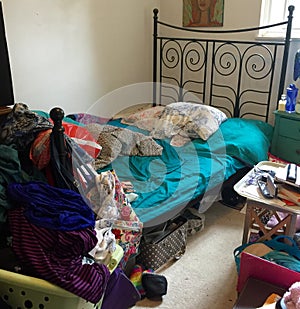 Disorganized bedroom filled with clutter. photo