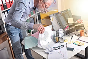 Disorganized businessman looking for documents, light effect