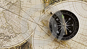 Disorientated spinning compass against map background closeup footage