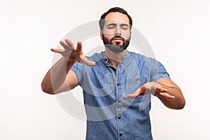 Disoriented bearded man moving with closed eyes, touching space with hands, confused with darkness, vision problems, eyesight
