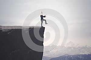 Disoriented businessman walks on the cliff photo
