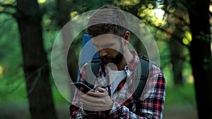 Disoriented camper searching for map in smartphone, geocaching and orienteering photo
