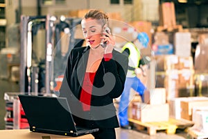 Dispatcher using phone at warehouse of forwarding photo