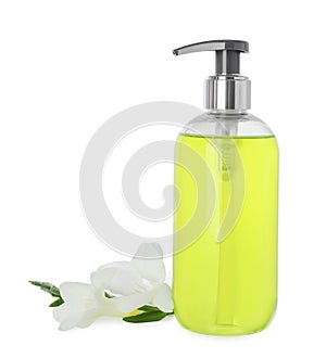 Dispenser of liquid soap and freesia flowers isolated on white