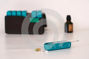 Dispenser for pills and tablets on the table. Unsharp background