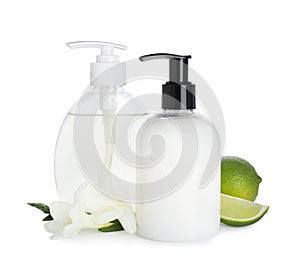 Dispensers with liquid soap, freesia flowers and limes on white background