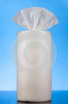 Dispensing container with bleach sanitizing wipes on blue background