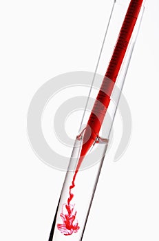 Dispensing liquid in pipette into test tube. Conceptual image