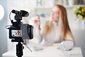 Display of camera recording video blog for blonde beauty blogger woman with make-up at home studio. Influencer vlogger photo