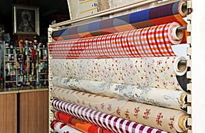 Tablecloths of various colors and designs for sale in a store. photo