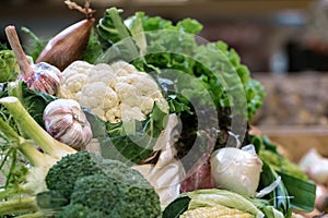 Display of fresh ripe organic broccoli, salad with greens and vegetables in cotton bag at the weekend farmer`s market