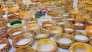 Display of gold bracelets for sale on white cloth