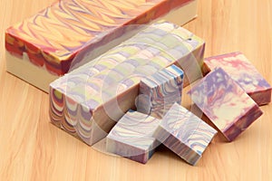Display of handcrafted soap blocks and bars on a wooden backdrop photo
