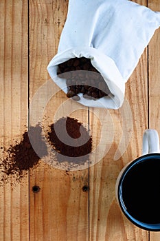 DISPLAY OF ROASTED COFFEE BEANS AND GROUNDS AND BLACK COFFEE IN A MUG