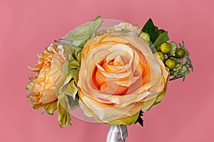 Display of Silk Roses and Flowers on Pink Background