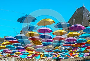 Display of umbrellas, floating towards a blue sky, in a conceptual tourism concept