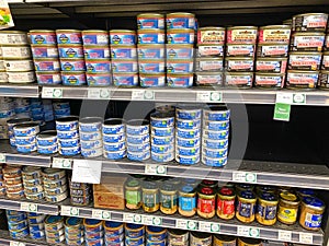 A display of various cans of tuna and salmon in the canned foods department of a Whole Foods Market Grocery Store