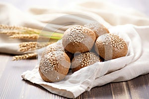 a display of whole grain bread rolls on a linen cloth