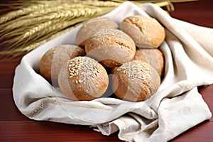 a display of whole grain bread rolls on a linen cloth