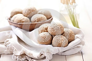 a display of whole grain bread rolls on a linen cloth