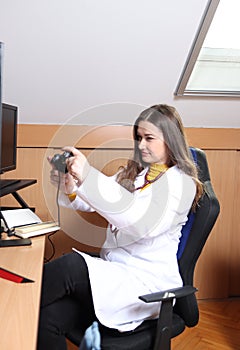 A display of a young female doctor playing on a computer. ph5