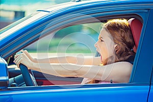 Displeased angry off aggressive woman driving car shouting screaming