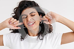 Displeased beautiful brunette girl plugging her ears