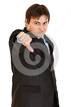 Displeased businessman showing thumbs down gesture