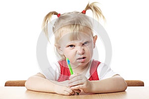 Displeased child with toothbrush photo